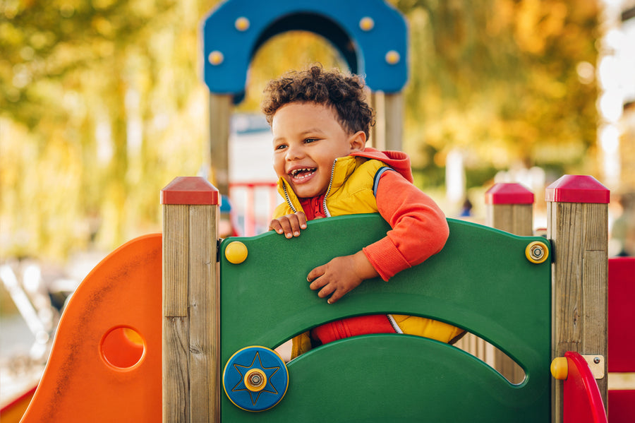 Adorable little 1-2 year old toddler boy having fun on playground
