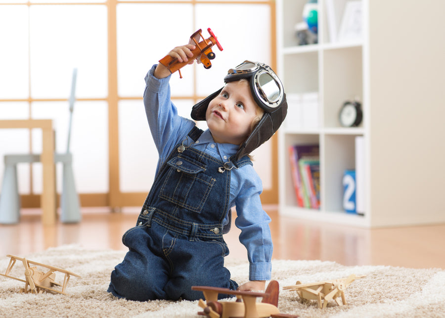 happy child toddler boy playing with toy airplane and dreaming of becoming a pilot