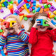 Happy 1-year-olds play with colorful plastic toy blocks.