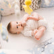 Cute baby lies in a white round bed